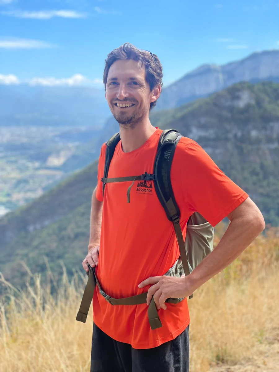Alexandre Eriani en montagne, dans une posture ouverte et souriante